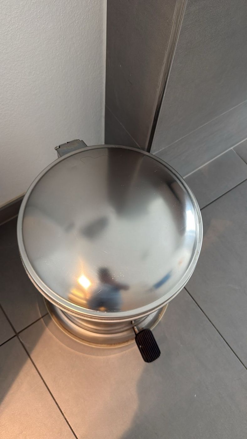 Spiegelblank polierter Edelstahl-Treteimer in einem gefliesten Sanitärraum
